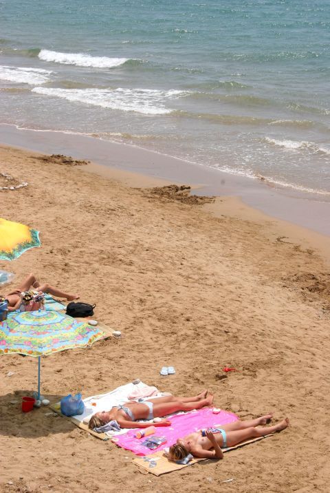 Sunbathing on the sandy shore of Arilias Beach