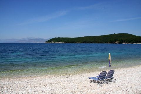 Two empty sunbeds on the pebbly Avlaki Beach