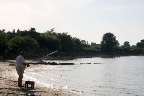 A man fishing at Roda Beach